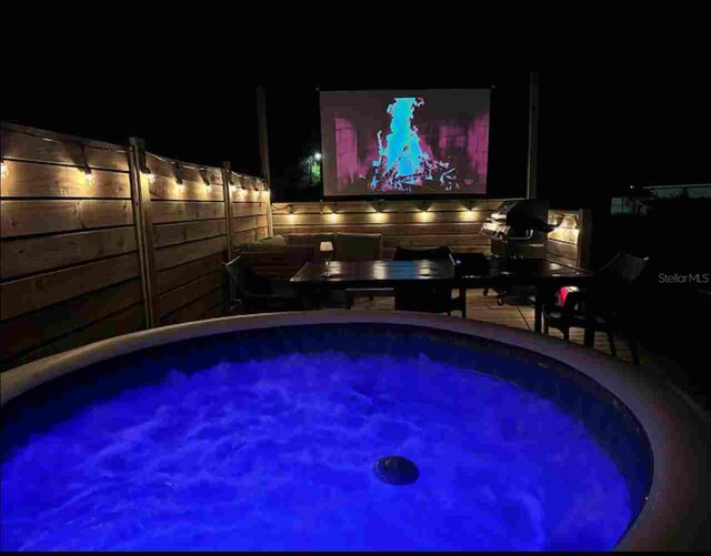 view of swimming pool with a hot tub
