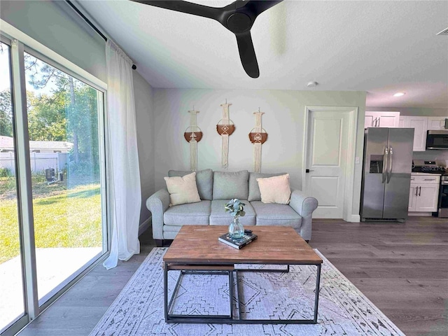 living room featuring a ceiling fan, dark wood finished floors, a textured ceiling, recessed lighting, and baseboards