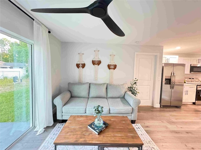 living room featuring a ceiling fan and light wood-style flooring