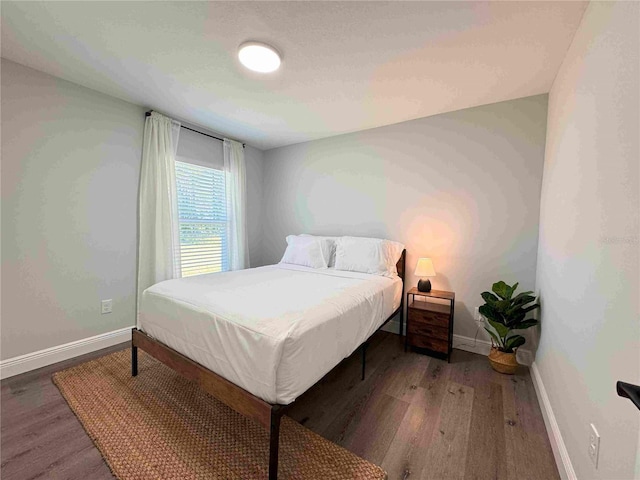 bedroom with wood finished floors and baseboards