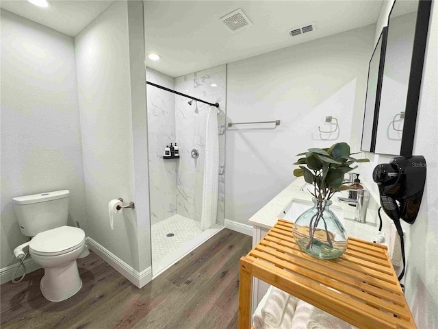 full bathroom with wood finished floors, a stall shower, toilet, baseboards, and recessed lighting