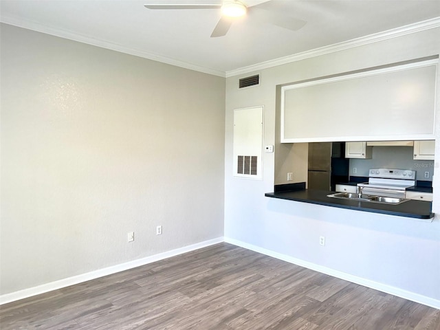 kitchen with white electric range, wood finished floors, dark countertops, ceiling fan, and ornamental molding