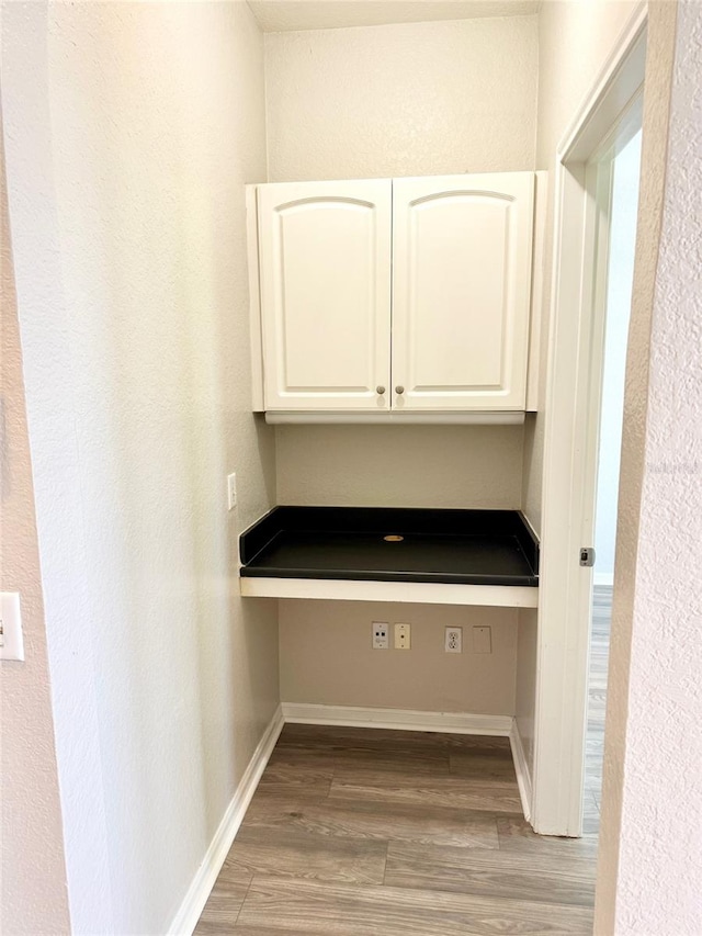 unfurnished office featuring light wood-style floors and baseboards