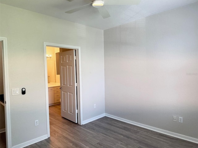 unfurnished room with a ceiling fan, dark wood finished floors, and baseboards
