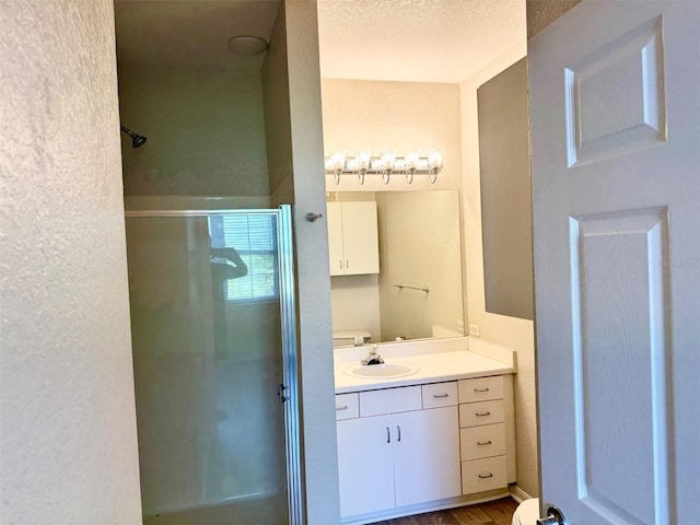 bathroom with a shower stall and vanity