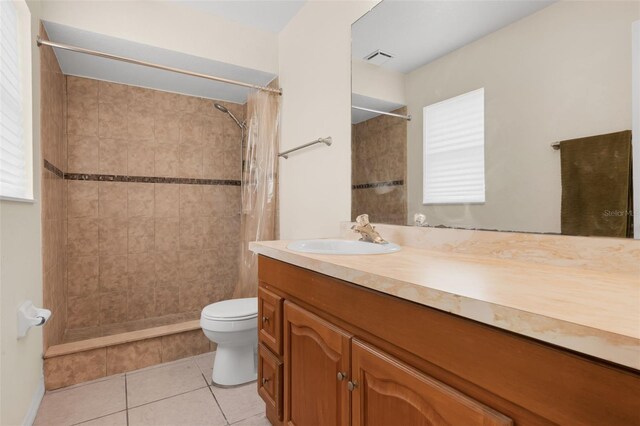 715 Wedge Ln, Poinciana, FL 34759 - full bathroom with a tile shower, toilet, vanity, and tile patterned flooring