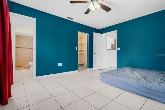 715 Wedge Ln, Poinciana, FL 34759 - unfurnished bedroom with tile patterned flooring, baseboards, ensuite bath, and a ceiling fan