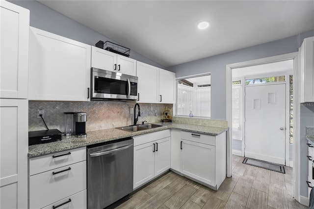 913 Moss Ln, Winter Park, FL 32789 - kitchen featuring stainless steel appliances, decorative backsplash, white cabinets, wood finish floors, and lofted ceiling
