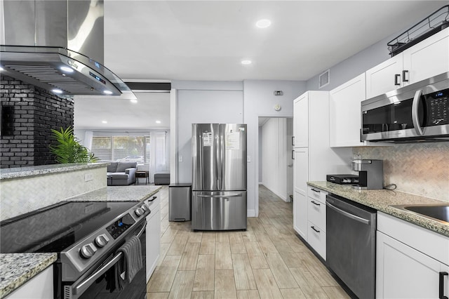 913 Moss Ln, Winter Park, FL 32789 - kitchen featuring appliances with stainless steel finishes, ventilation hood, white cabinets, light wood-style floors, and light stone counters