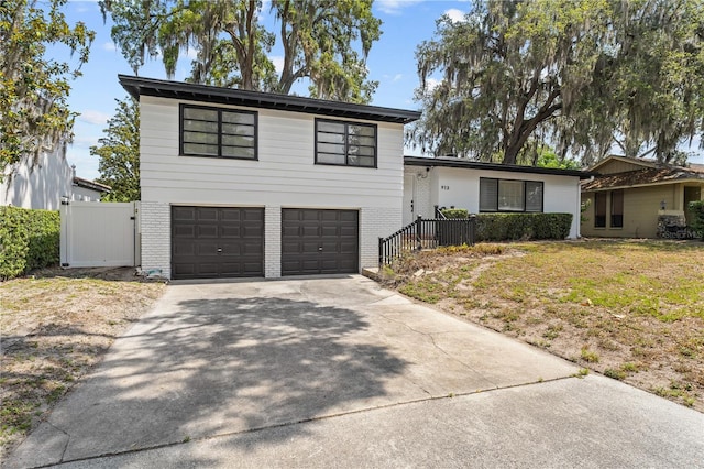 913 Moss Ln, Winter Park, FL 32789 - tri-level home featuring a garage, brick siding, and driveway