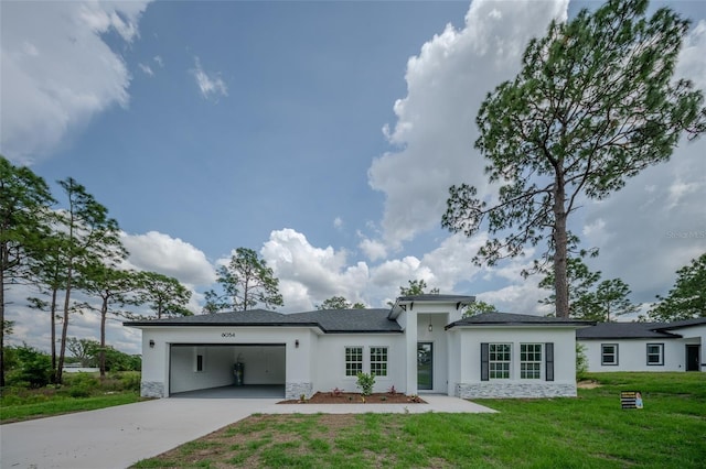 prairie-style home with stone siding, stucco siding, an attached garage, driveway, and a front lawn