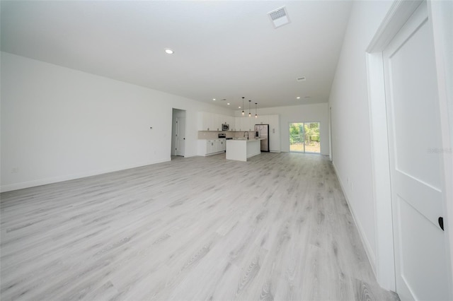 unfurnished living room with light wood-style flooring, baseboards, and recessed lighting