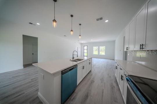 kitchen with dishwasher, a sink, open floor plan, light wood-style flooring, and stainless steel electric stove