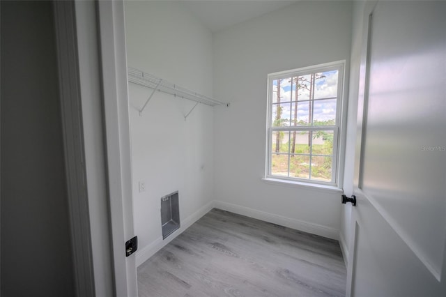 laundry room with light wood-type flooring, baseboards, and electric dryer hookup