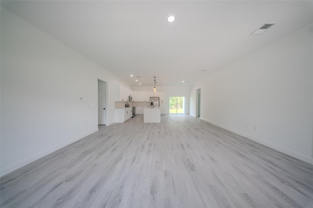 unfurnished living room with light wood-style floors, baseboards, and recessed lighting