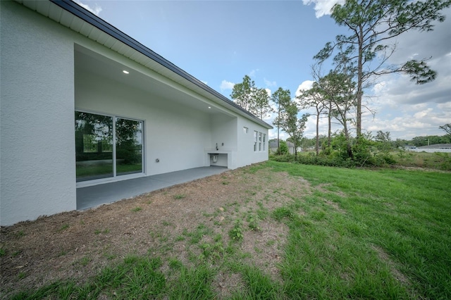 view of grassy yard featuring a patio area