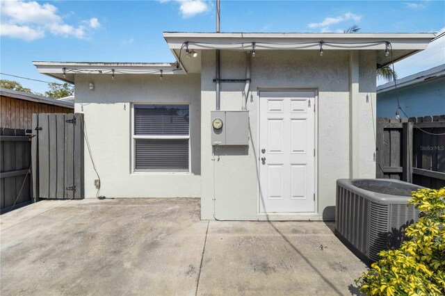 18 S D St, Lake Worth, FL 33460 - doorway to property featuring central air condition unit, stucco siding, fence, and a patio