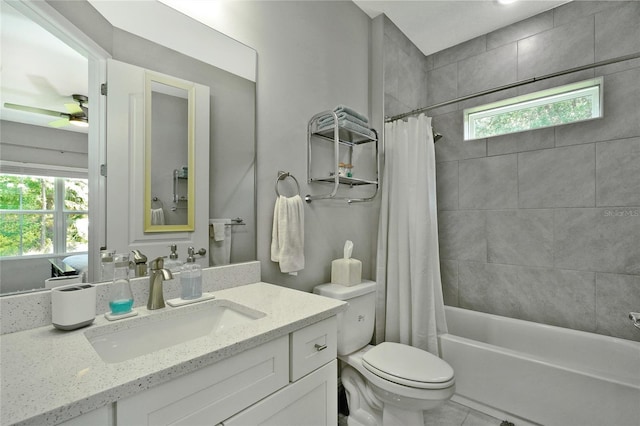 bathroom with toilet, vanity, a ceiling fan, shower / tub combo, and tile patterned flooring