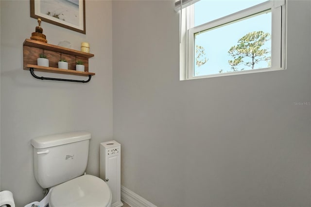 bathroom with toilet and baseboards