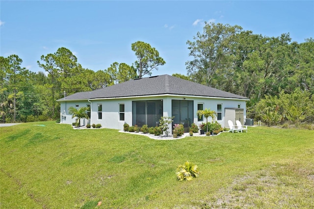 back of property featuring a lawn, stucco siding, and central AC