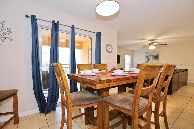 dining area with light tile patterned floors, baseboards, and a ceiling fan