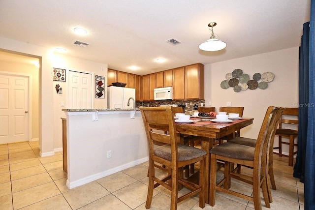 dining area featuring light tile patterned floors and baseboards