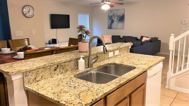 kitchen with a sink, dishwasher, open floor plan, a ceiling fan, and light tile patterned flooring