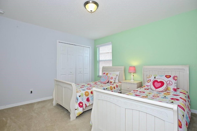 bedroom featuring light carpet, baseboards, and a closet