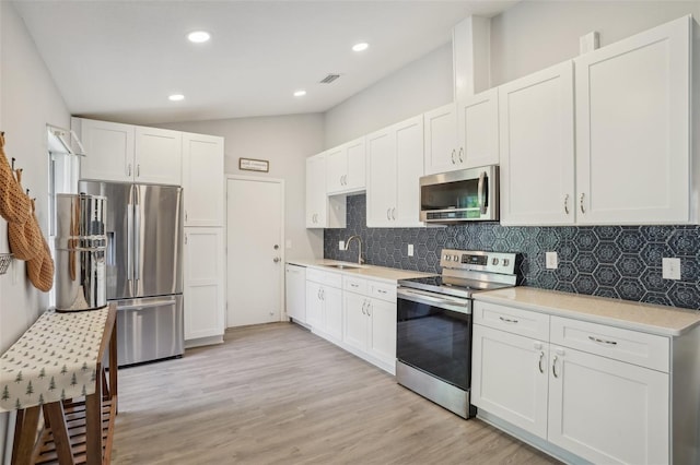 620 Fruitwood Ave, Winter Springs, FL 32708 - kitchen with stainless steel appliances, a sink, decorative backsplash, light countertops, and vaulted ceiling