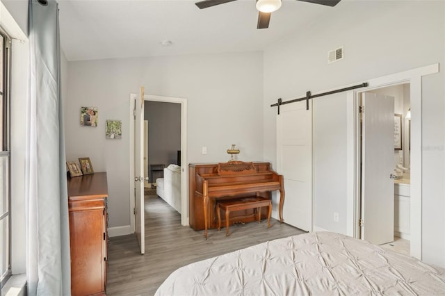 620 Fruitwood Ave, Winter Springs, FL 32708 - bedroom featuring wood finished floors, a barn door, lofted ceiling, and ceiling fan