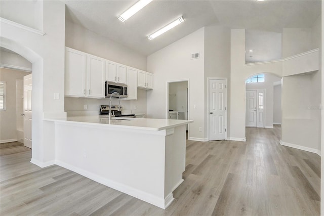 19540 Glen Elm Way, Orlando, FL 32833 - kitchen featuring stainless steel appliances, high vaulted ceiling, arched walkways, a peninsula, and light countertops