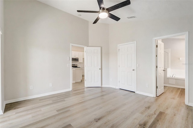 19540 Glen Elm Way, Orlando, FL 32833 - unfurnished bedroom featuring light wood finished floors, baseboards, ensuite bath, high vaulted ceiling, and a ceiling fan