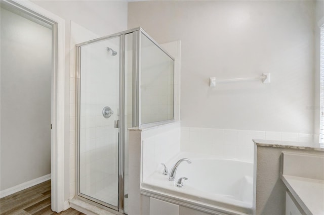 19540 Glen Elm Way, Orlando, FL 32833 - bathroom with a shower stall, a bath, and wood finished floors