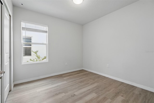 empty room with light wood finished floors and baseboards