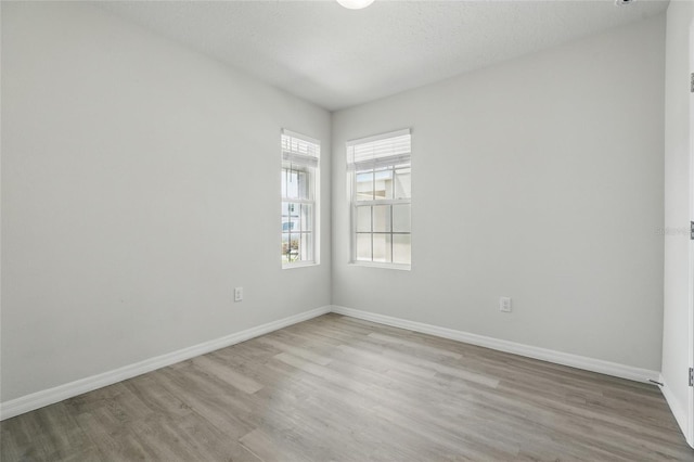 spare room with wood finished floors and baseboards