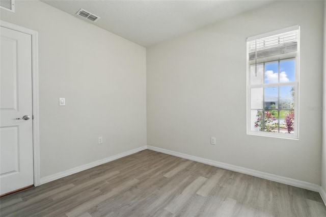 spare room featuring light wood-style floors and baseboards