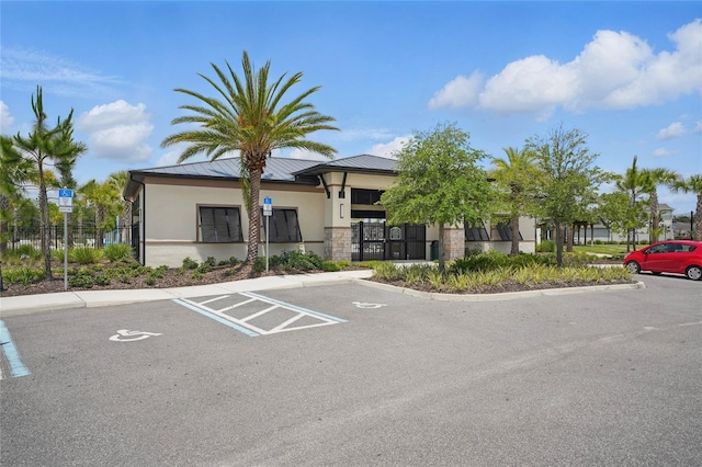 view of building exterior with uncovered parking and fence