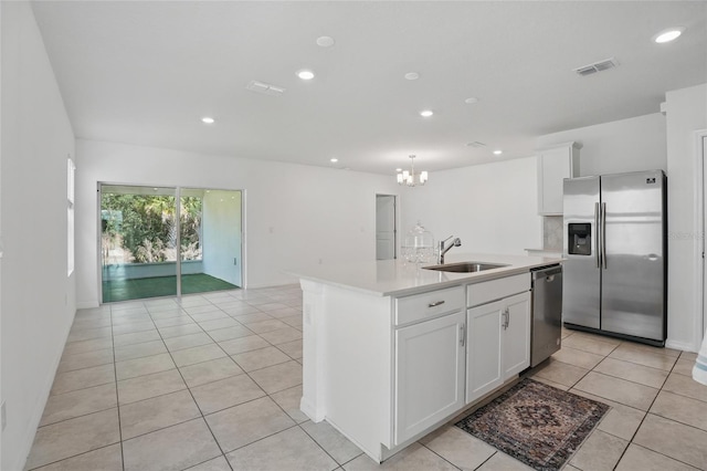 kitchen featuring stainless steel appliances, a sink, light countertops, a chandelier, and light tile patterned flooring