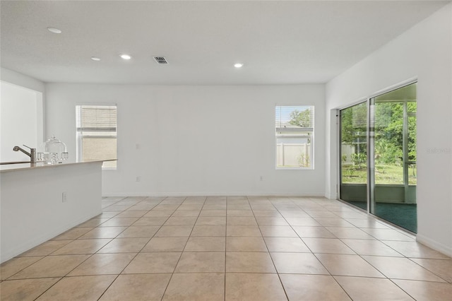 unfurnished room featuring recessed lighting, light tile patterned floors, and baseboards
