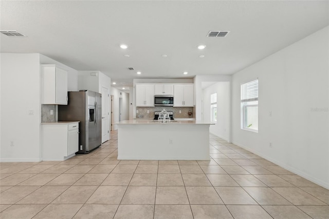 kitchen featuring appliances with stainless steel finishes, tasteful backsplash, light tile patterned flooring, light countertops, and recessed lighting