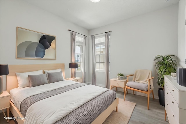 bedroom featuring light wood-style floors and baseboards