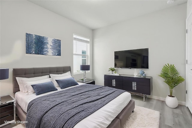 bedroom featuring wood finished floors and baseboards