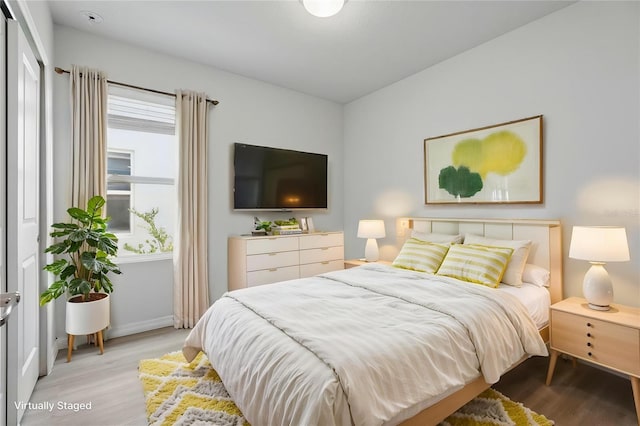 bedroom featuring wood finished floors and baseboards