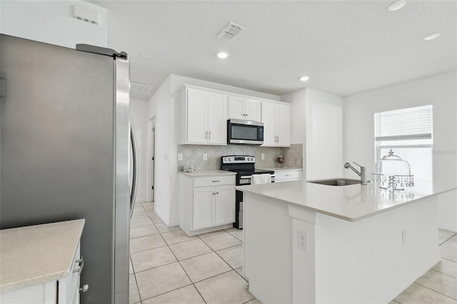 kitchen with stainless steel appliances, a sink, decorative backsplash, light tile patterned floors, and light countertops