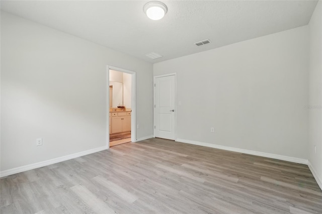 empty room featuring light wood-style flooring and baseboards
