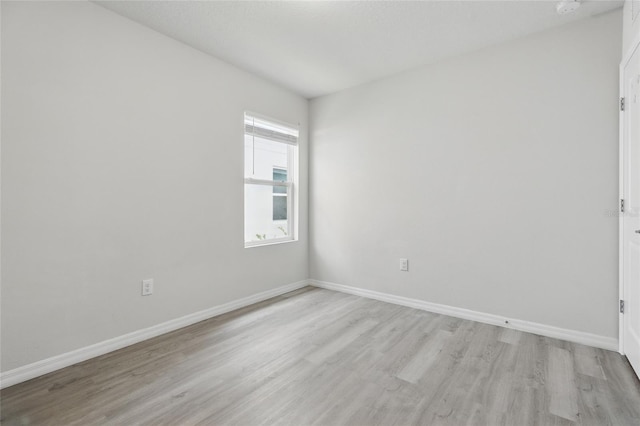 empty room with light wood-style flooring and baseboards