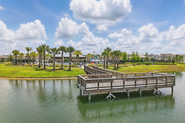 dock area with a water view and a yard