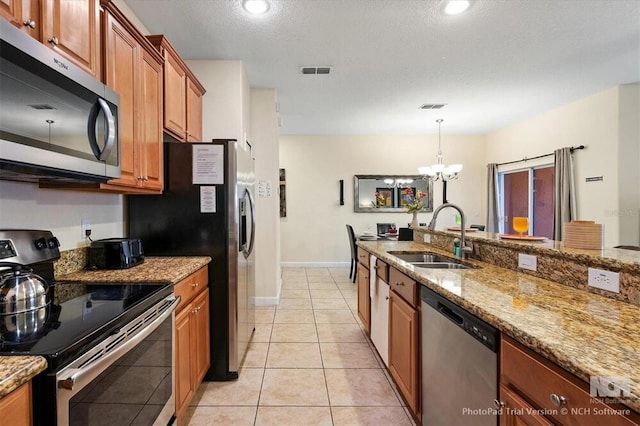 8941 Bismarck Palm Rd, Kissimmee, FL 34747 - kitchen with stainless steel appliances, a sink, brown cabinets, a chandelier, and light stone counters