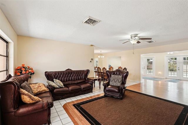 1301 Lucaya Ave, Venice, FL 34285 - living room with a ceiling fan, a chandelier, a textured ceiling, french doors, and light tile patterned flooring