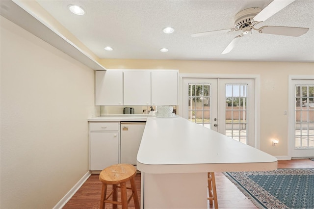 1301 Lucaya Ave, Venice, FL 34285 - kitchen featuring a peninsula, french doors, a kitchen breakfast bar, wood finished floors, and light countertops